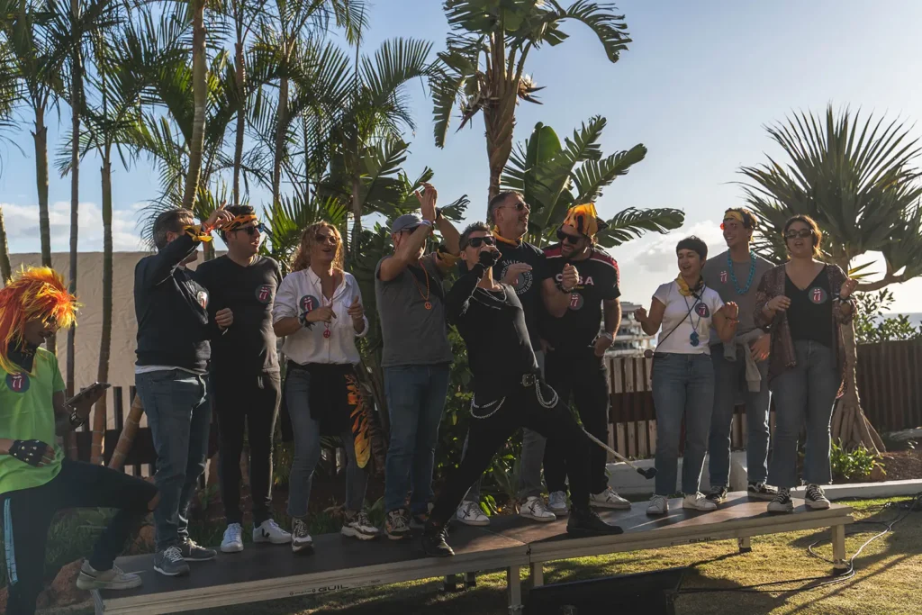 Un equipo de trabajo participando con entusiasmo en una actividad de team building musical al aire libre en Tenerife, organizada por Eventalia Group.