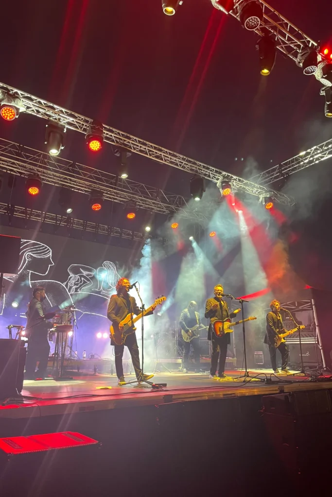 Banda actuando encima del escenario.